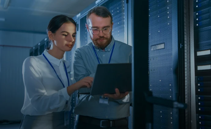 Casal de técnicos segurando notebook